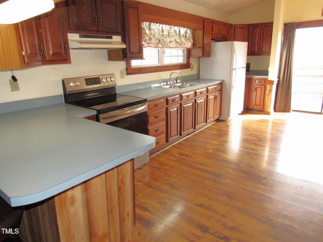 kitchen with light wood-style flooring, freestanding refrigerator, stainless steel range with electric cooktop, under cabinet range hood, and a sink