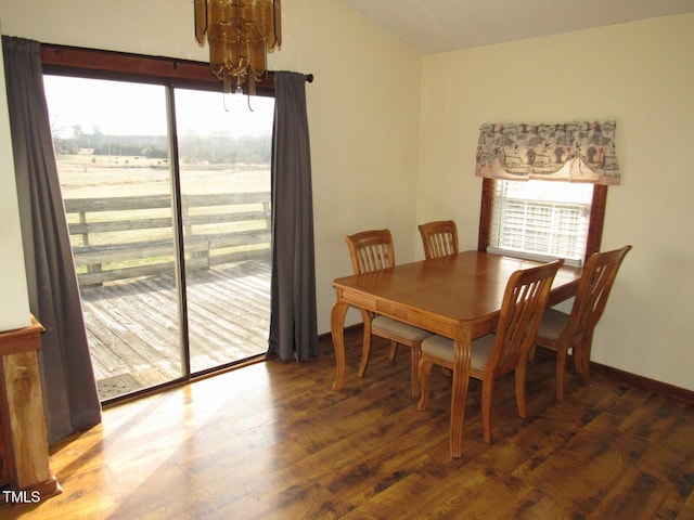 dining room with a chandelier, wood finished floors, a wealth of natural light, and baseboards