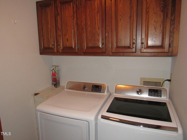 washroom featuring cabinet space and separate washer and dryer