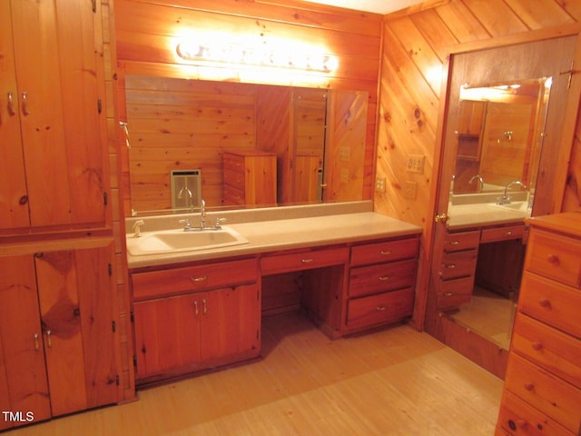 bathroom featuring wooden walls, wood finished floors, and vanity