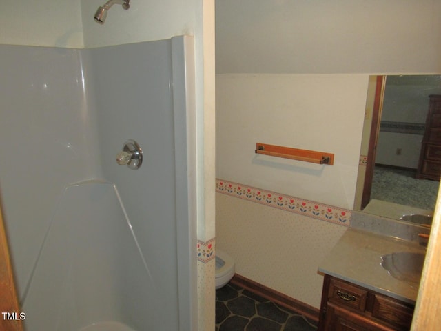 bathroom featuring toilet, walk in shower, and vanity