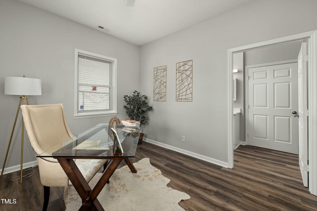 office space with dark wood-type flooring, visible vents, and baseboards