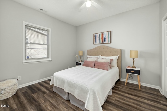 bedroom with a ceiling fan, wood finished floors, visible vents, and baseboards