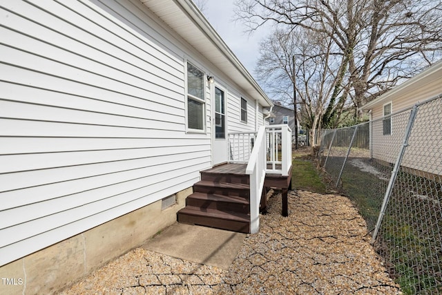 view of side of property with crawl space and fence