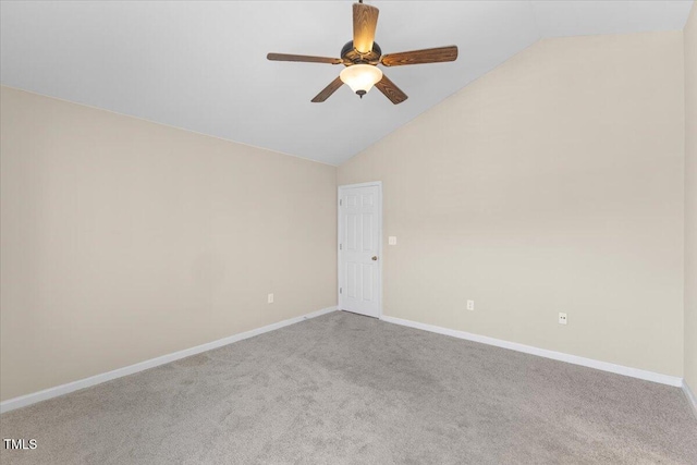 carpeted spare room featuring lofted ceiling, ceiling fan, and baseboards