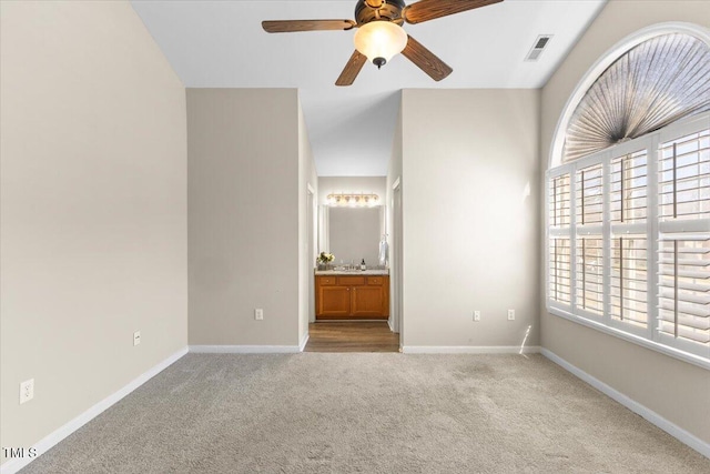 unfurnished bedroom with visible vents, baseboards, connected bathroom, ceiling fan, and carpet