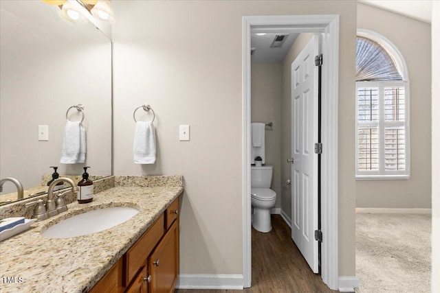 bathroom featuring baseboards, vanity, and toilet