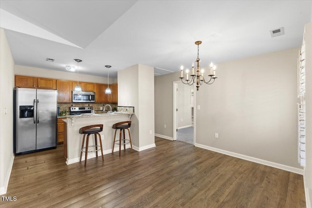 kitchen featuring dark wood-style flooring, visible vents, appliances with stainless steel finishes, tasteful backsplash, and brown cabinetry