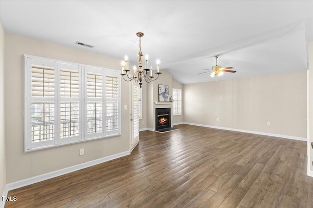 unfurnished living room featuring a warm lit fireplace, visible vents, lofted ceiling, wood finished floors, and ceiling fan with notable chandelier