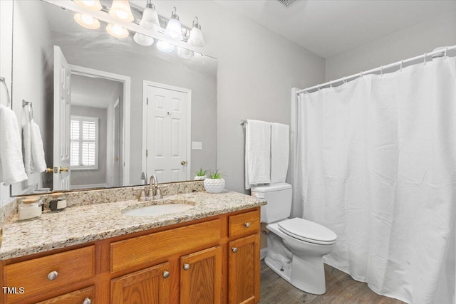 bathroom featuring toilet, wood finished floors, and vanity