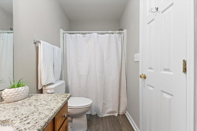 full bathroom with toilet, baseboards, wood finished floors, and vanity