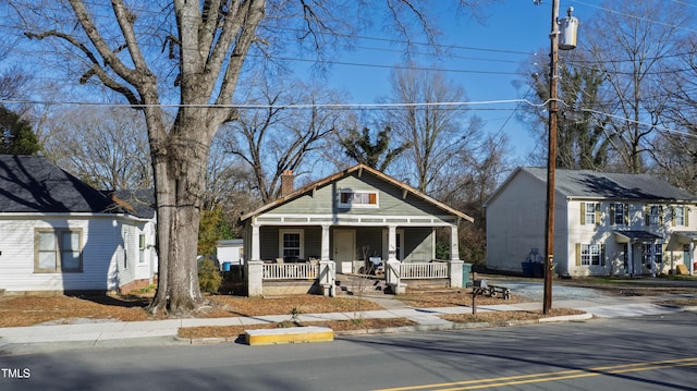 bungalow-style home with covered porch and a chimney