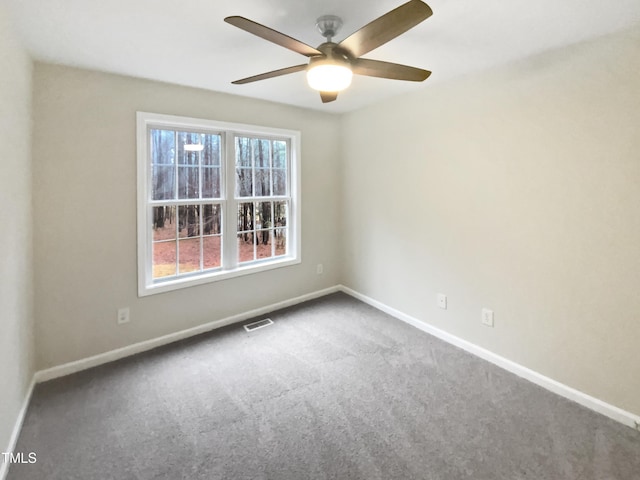 empty room featuring carpet floors, a ceiling fan, visible vents, and baseboards