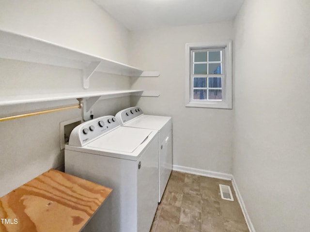 clothes washing area with laundry area, visible vents, washer and clothes dryer, and baseboards