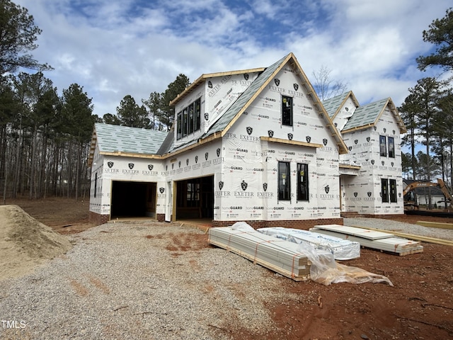 unfinished property with gravel driveway and a garage