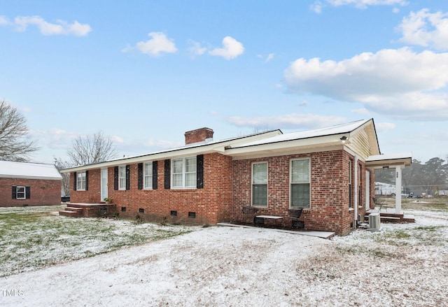 ranch-style home with brick siding, crawl space, a chimney, and cooling unit