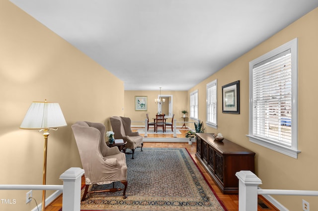 living room featuring baseboards, visible vents, and a chandelier