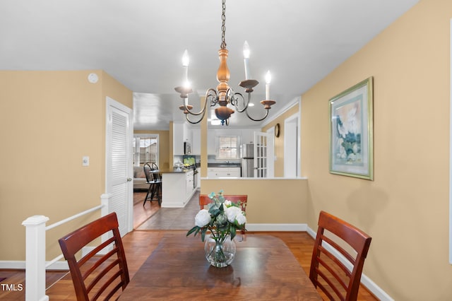 dining room with baseboards and a notable chandelier