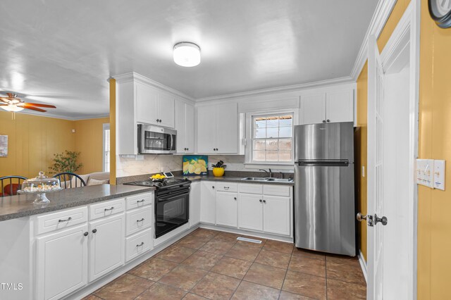 kitchen featuring dark countertops, white cabinetry, stainless steel appliances, and a sink