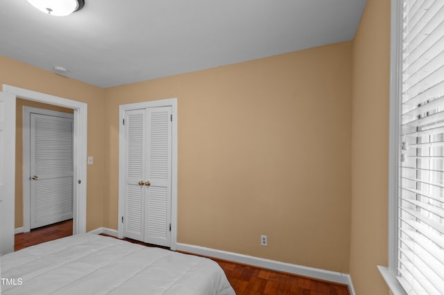 bedroom featuring baseboards, a closet, and wood finished floors