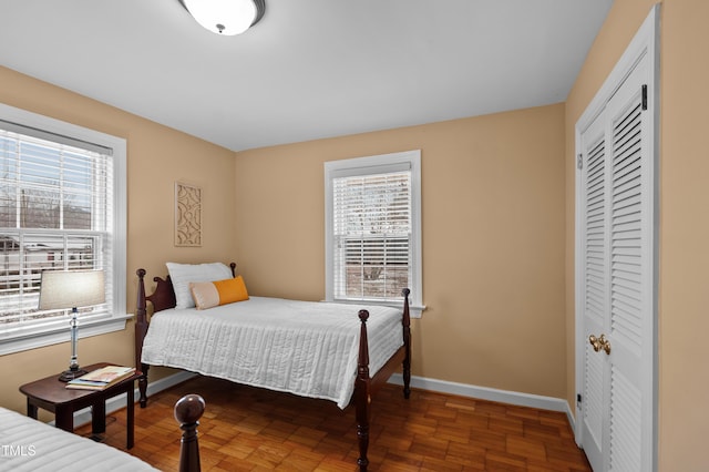 bedroom featuring a closet, baseboards, and wood finished floors