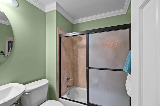 bathroom with combined bath / shower with glass door, ornamental molding, a sink, and toilet