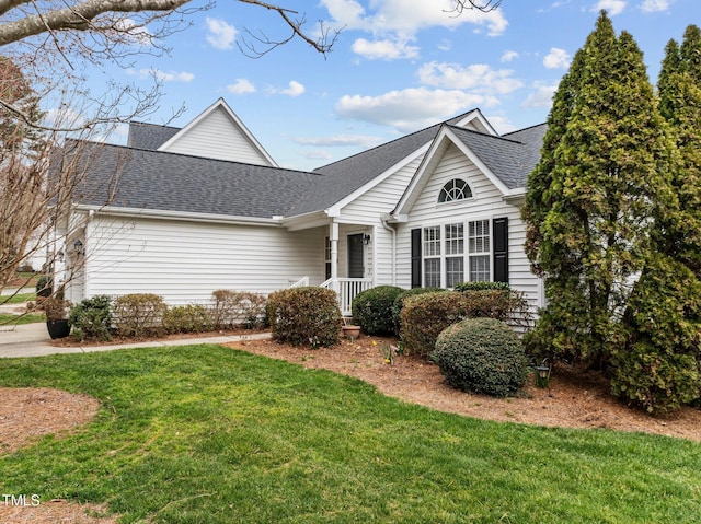 view of front of property with a front yard and a shingled roof