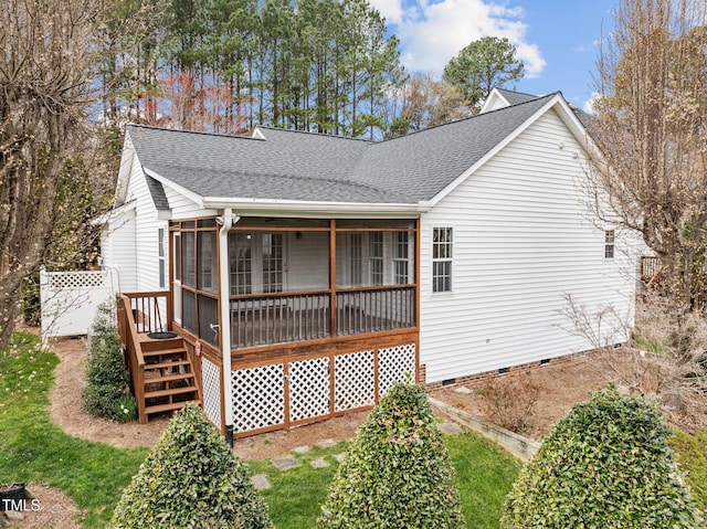 back of property with crawl space, a shingled roof, and a sunroom