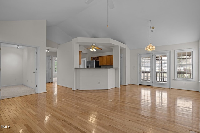 unfurnished living room featuring high vaulted ceiling, a ceiling fan, light wood-style floors, and baseboards