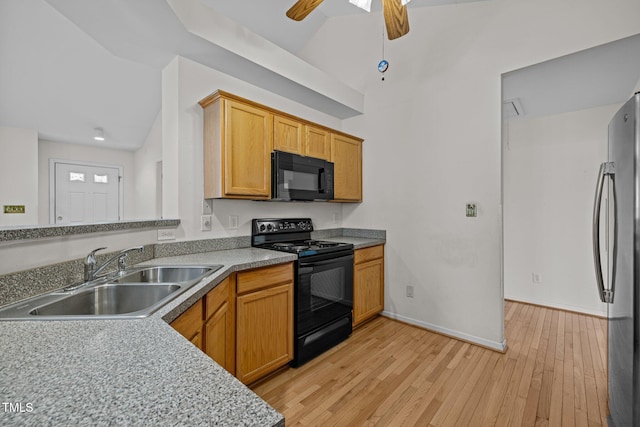 kitchen featuring light wood-type flooring, black appliances, a sink, baseboards, and ceiling fan