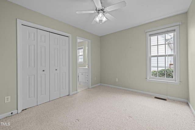 unfurnished bedroom with carpet, baseboards, visible vents, ensuite bath, and a closet