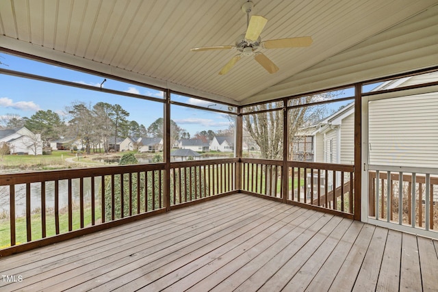 unfurnished sunroom with a residential view, lofted ceiling, and ceiling fan