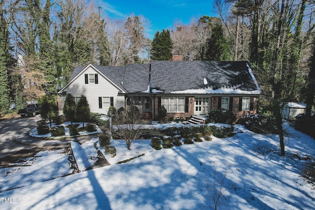 view of front of home featuring brick siding and a chimney