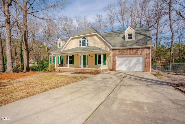 view of front of property with an attached garage, covered porch, brick siding, fence, and concrete driveway