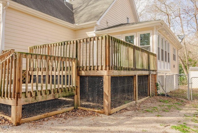 back of house with a shingled roof, an outbuilding, fence, and a deck