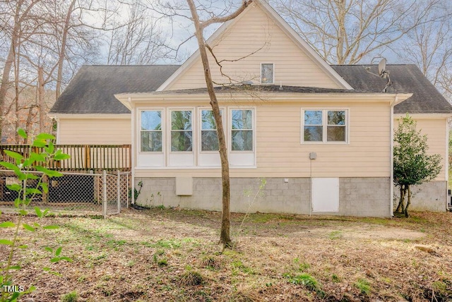 back of property featuring roof with shingles