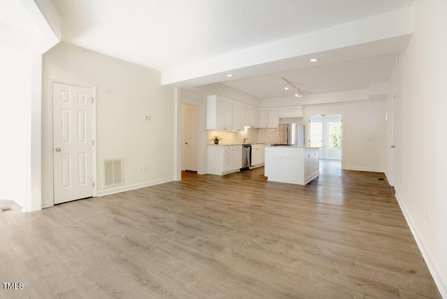 unfurnished living room featuring light wood-type flooring, baseboards, and visible vents