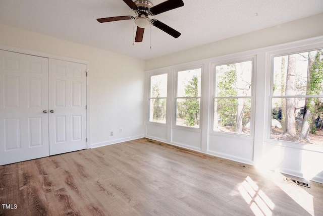 interior space featuring multiple windows, visible vents, and wood finished floors