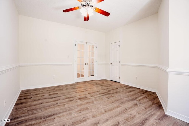 spare room with a ceiling fan, baseboards, wood finished floors, and french doors