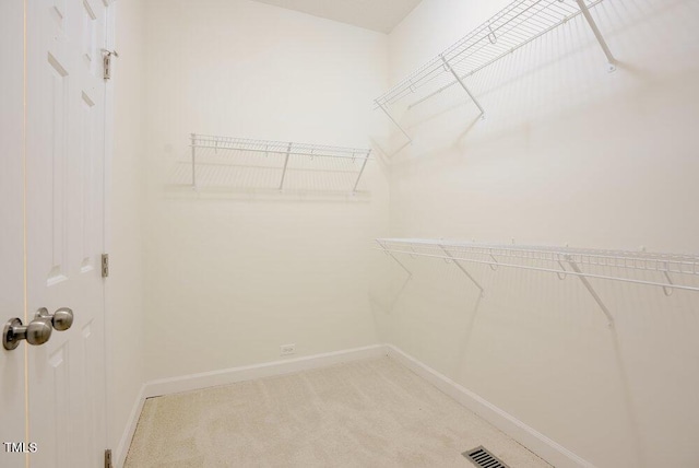 walk in closet featuring light carpet and visible vents