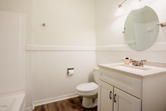 full bathroom featuring a bathtub, vanity, toilet, and wood finished floors