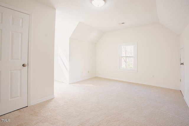 bonus room featuring carpet flooring, vaulted ceiling, a textured ceiling, and baseboards