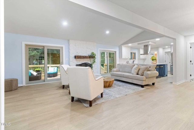 living area featuring lofted ceiling with beams, recessed lighting, a fireplace, baseboards, and light wood-type flooring