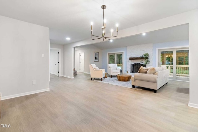 living room with plenty of natural light, light wood finished floors, a fireplace, and baseboards