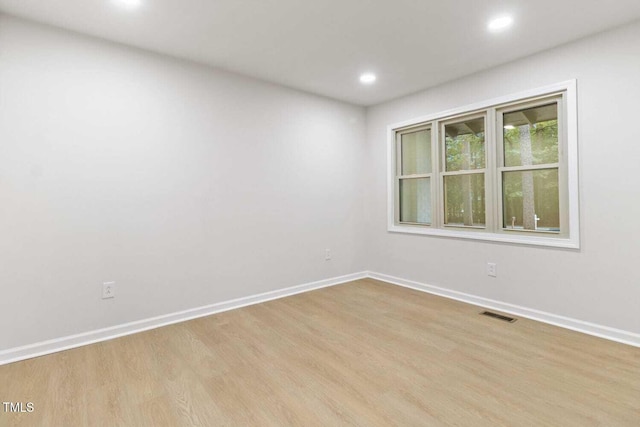 empty room featuring baseboards, visible vents, wood finished floors, and recessed lighting