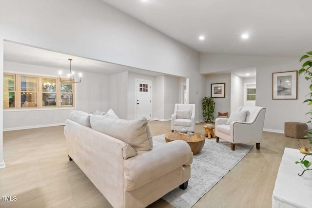 living area featuring high vaulted ceiling, recessed lighting, a chandelier, light wood-type flooring, and baseboards