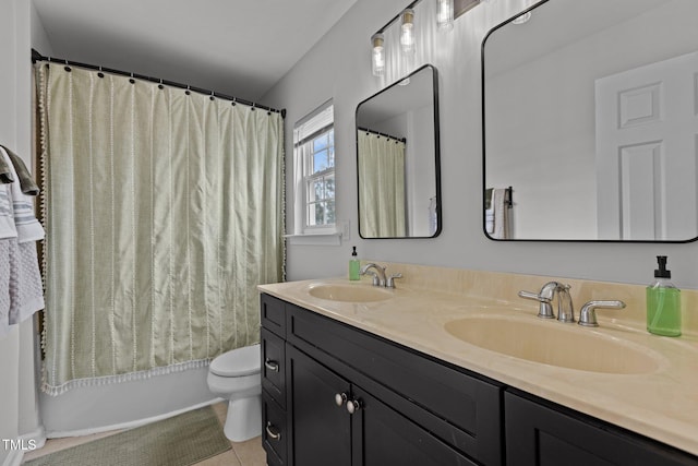 bathroom with toilet, double vanity, a sink, and tile patterned floors