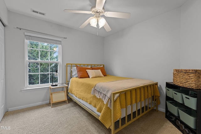 carpeted bedroom with baseboards, visible vents, and ceiling fan