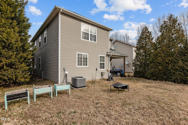 rear view of property with a lawn and central air condition unit