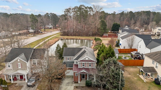 birds eye view of property with a water view, a residential view, and a view of trees